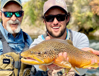 2 men showing off the trout they caught in Aspen