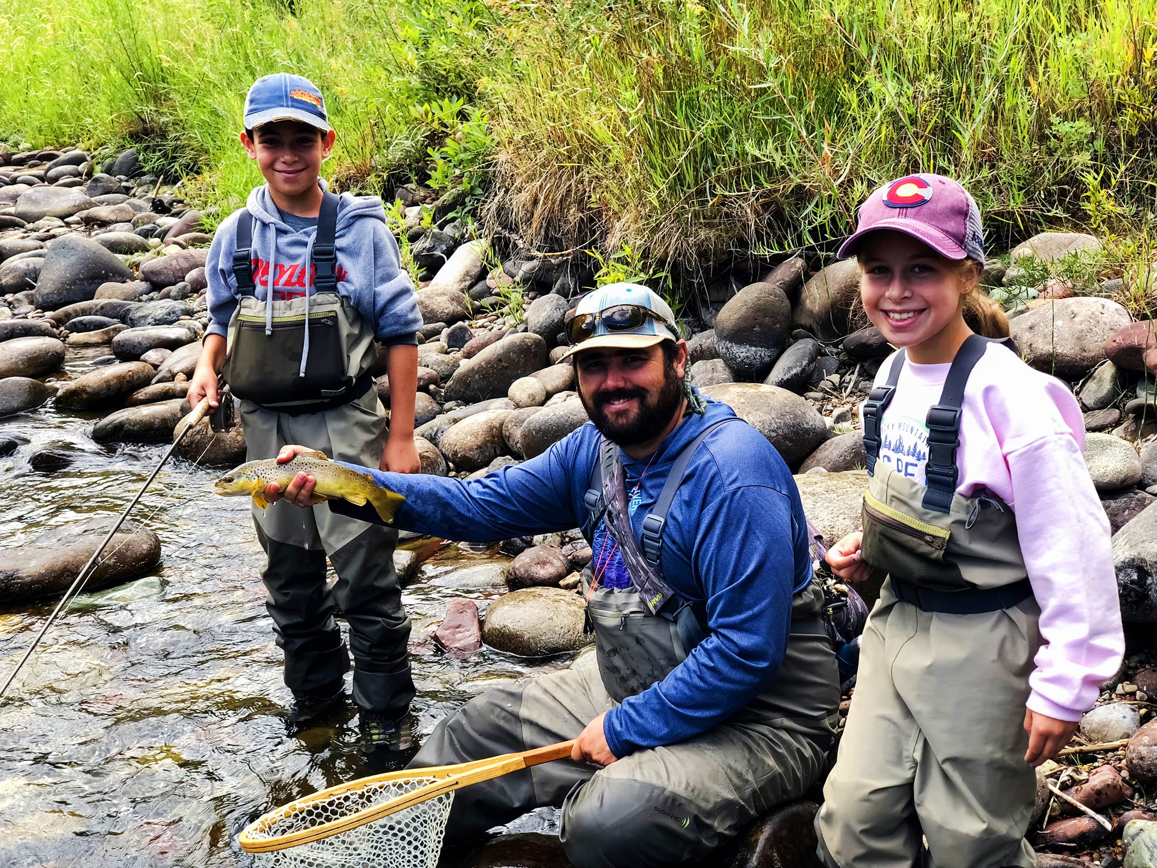 family showing the fish they caught fly fishing in Aspen