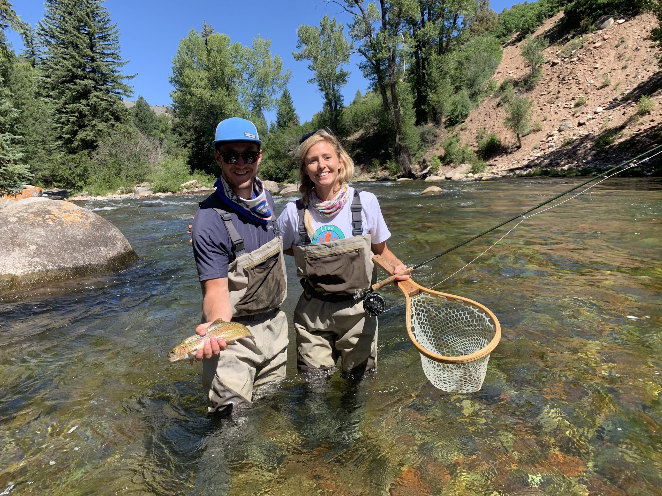 a couple showing the rainbow trout they caught in Aspen