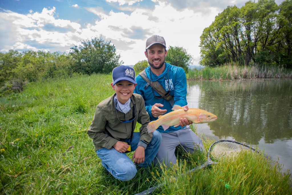 a man and his son showing the rainbow trout they caught in Aspen