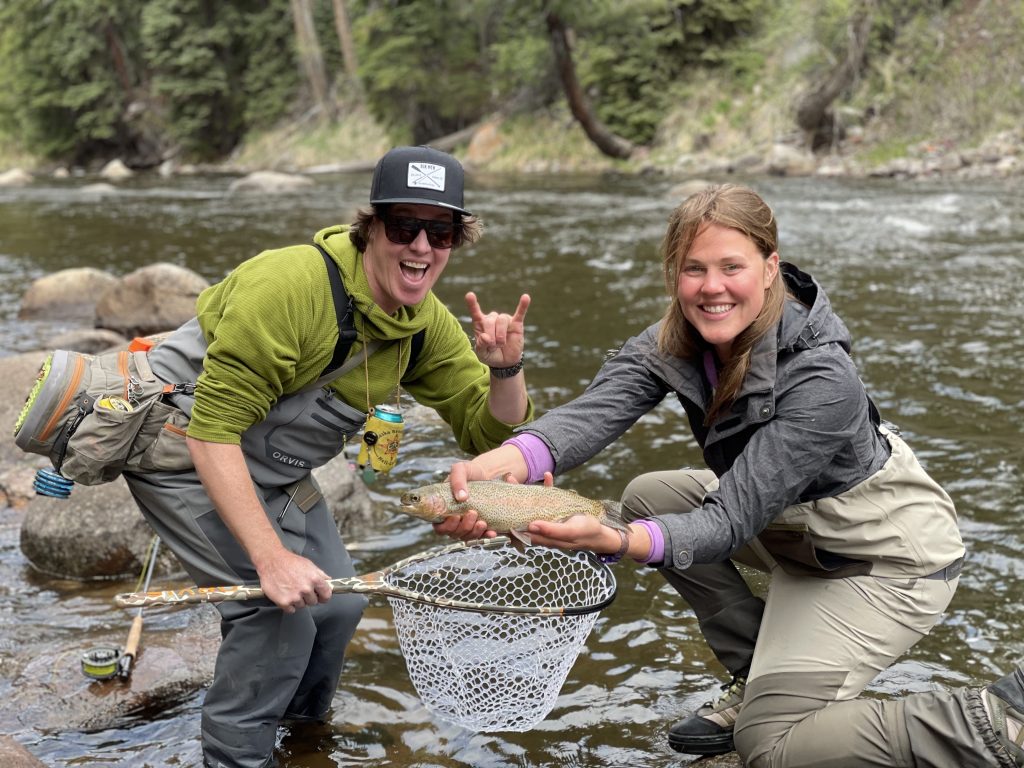 a couple showing the rainbow trout they caught in Aspen