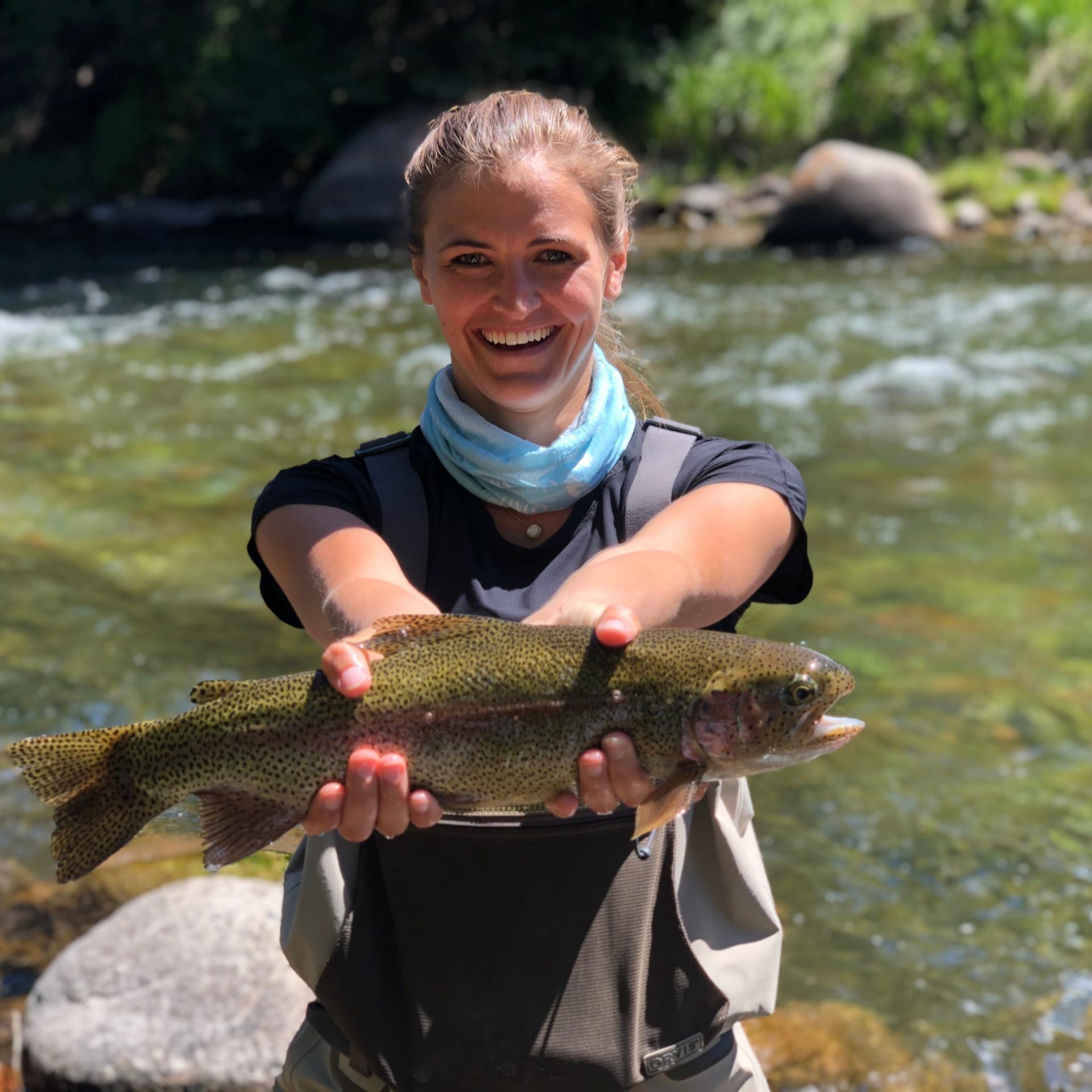 a woman showing the rainbow trout she caught in Aspen
